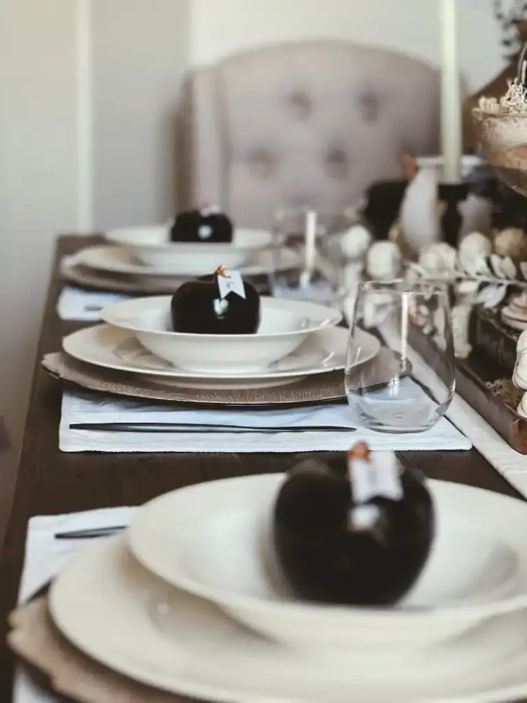 3 white place settings with a black apple placard in the middle of the bowls
