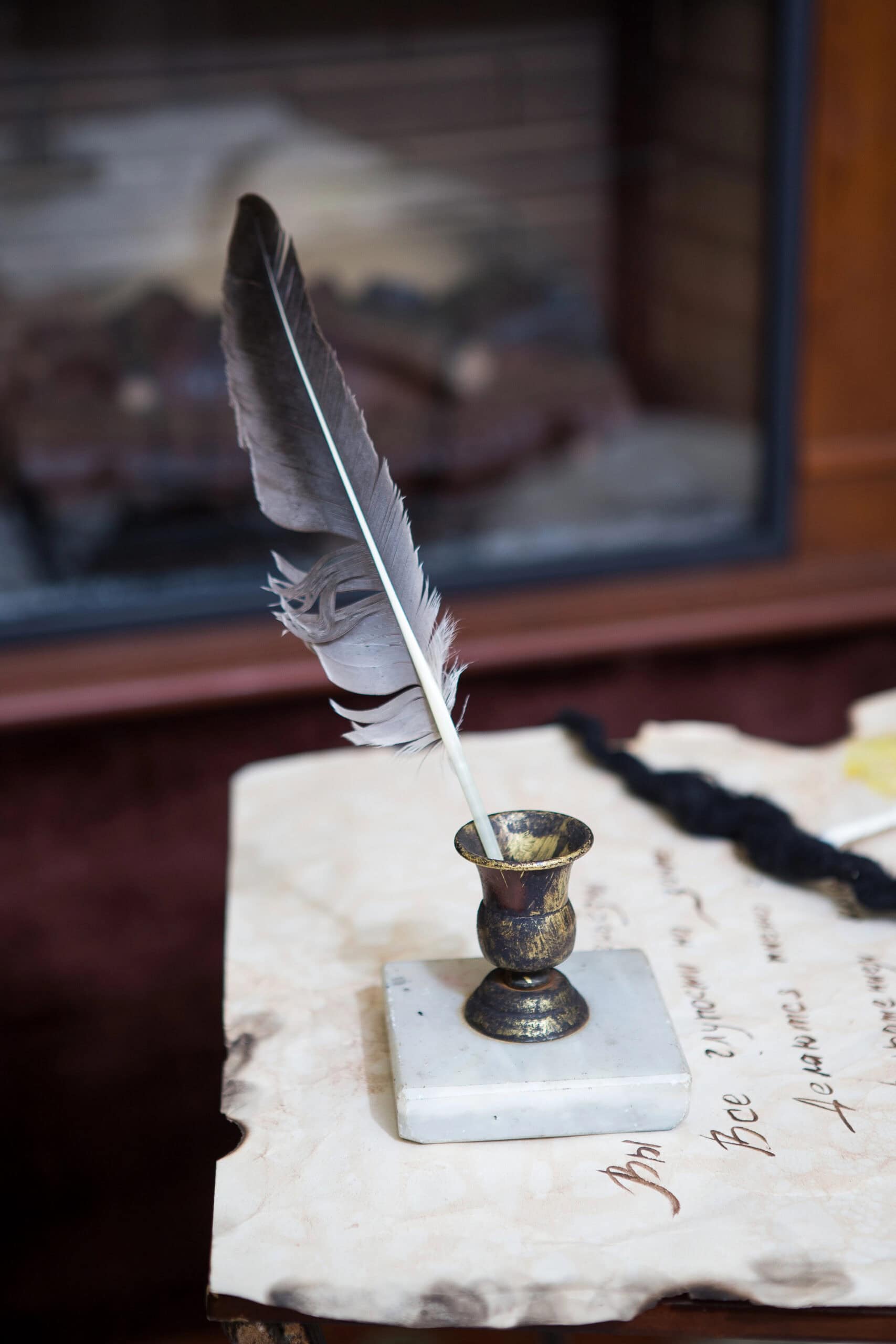 A quill pen on a desk on top of paper