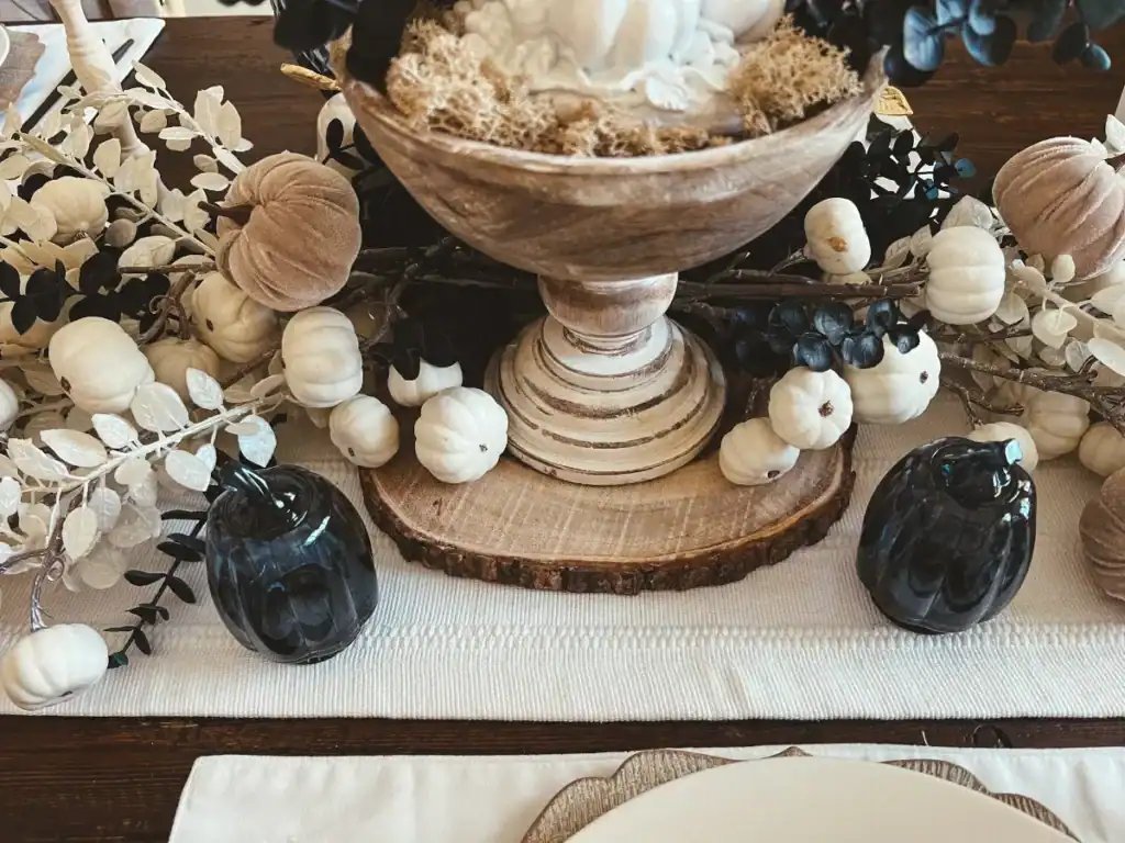 A Tree Slice under a pedestal on a table with a white table runner