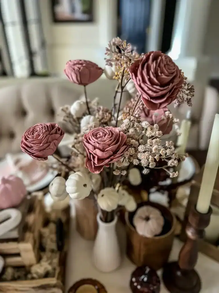 A close up of pink paper flowers in a white vase