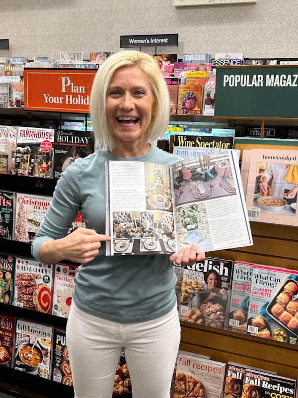 Woman holding open magazine in bookstore.
