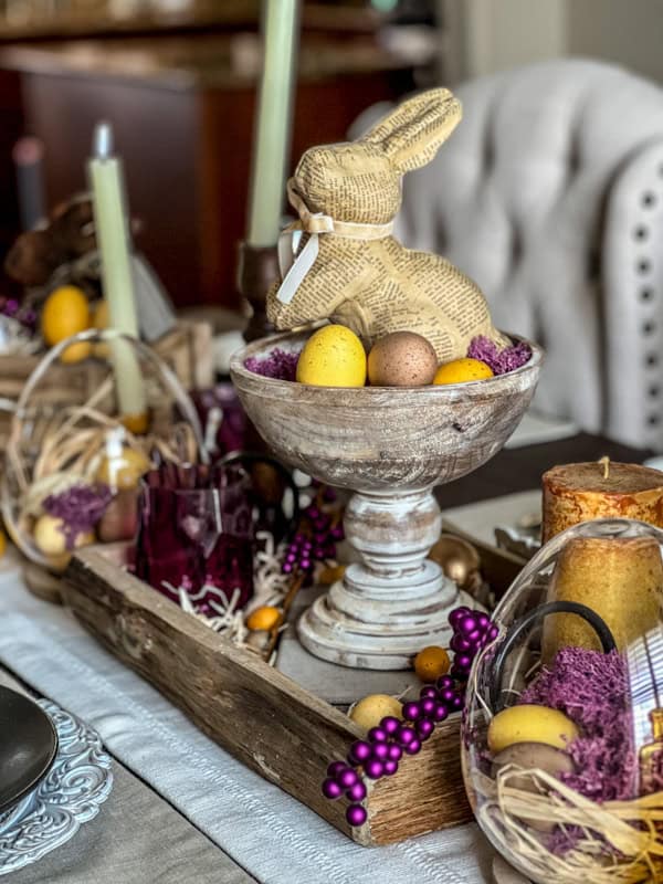 Elegant Easter centerpiece with a rustic newspaper bunny and colorful eggs for spring celebrations.