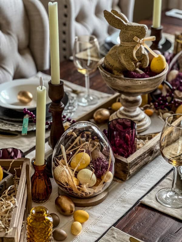 Elegant Easter table setting with purple and yellow accents, candles, and festive decorations.