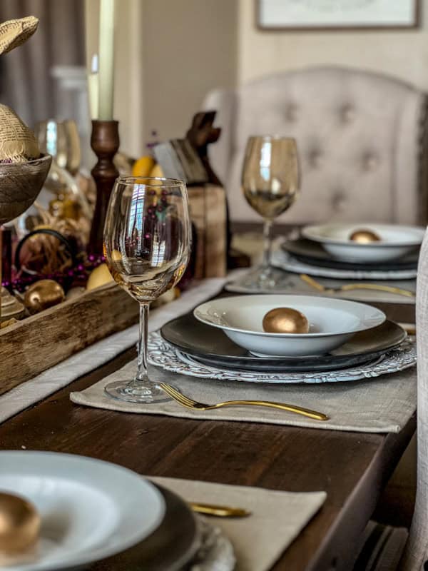 Easter table setting with gold accents, white plates, and wine glasses for spring celebration.