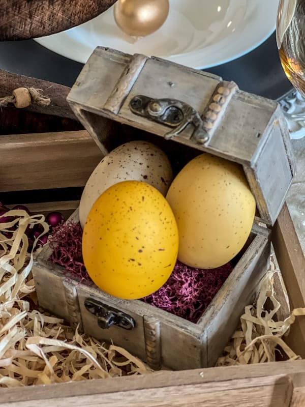 Easter eggs in a vintage wooden chest with spring decor, perfect for a festive spring tablescape.